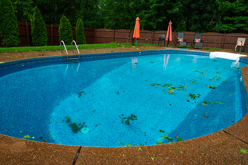 Messy pool and patio after a windy rain storm at a residential home, Midwest, Indiana, USA
