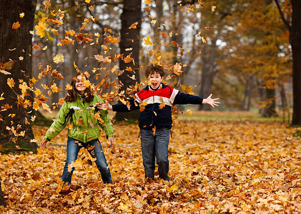 istock Girl and boy throwing up leaves in park 148471749