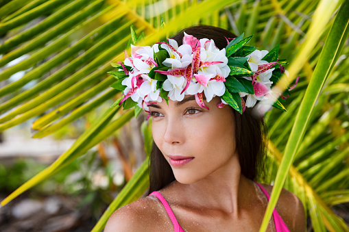 Tahiti beauty woman wearing flower head wreath traditional Tahitian cultural accessory. Bora Bora, French Polynesia. Beautiful Asian multiracial woman in 30s