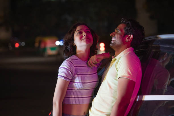istock Happy couple leaning on car and spending leisure time at night 1484719165