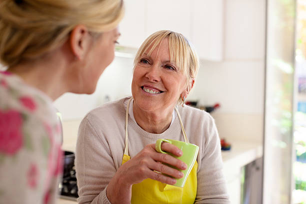 istock Mother and daughter in kitchen talking over cup of coffee 148472190