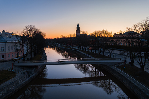 Aerial view of a person with bicycle on Kirjastosilta bridge in Turku, Finland just before sunrise
