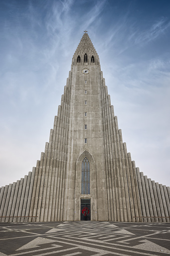 Hallgrímskirkja Church of Iceland. Architecture shot of famous iconic Hallgrimskirkja Lutheran Church (Church of Iceland) in downtown Reykjavik against sunny blue sky. The Hallgrimskirkja Church is with 74.5 meters the largest church on Iceland. The church is named after the Icelandic poet and clergyman Hallgrímur Pétursson. The Hallgrímskirkja is known for its curved spire and side wings, it is an important symbol for Iceland's national identity since its completion in the year 1986. Reykjavik, Iceland, Northern Europe