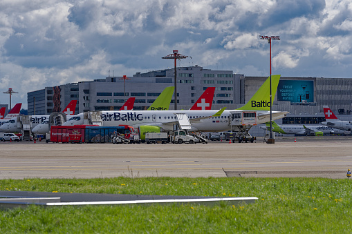 Parked Swiss and Air Baltic airplanes parked at Swiss Airport Zürich Kloten on a sunny spring morning. Photo taken April 14th, 2023, Kloten, Canton Zurich, Switzerland.