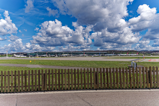 Parked airplanes at terminal Dock Midfield at Swiss Airport Zürich Kloten on a sunny spring day. Movie shot April 14th, 2023, Kloten, Canton Zurich, Switzerland.