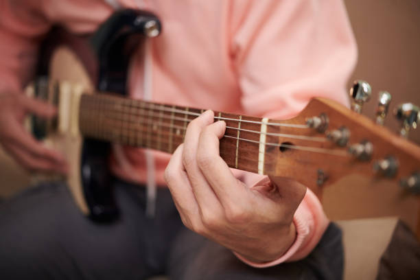 istock Man Playing Guitar at Home 1484739378