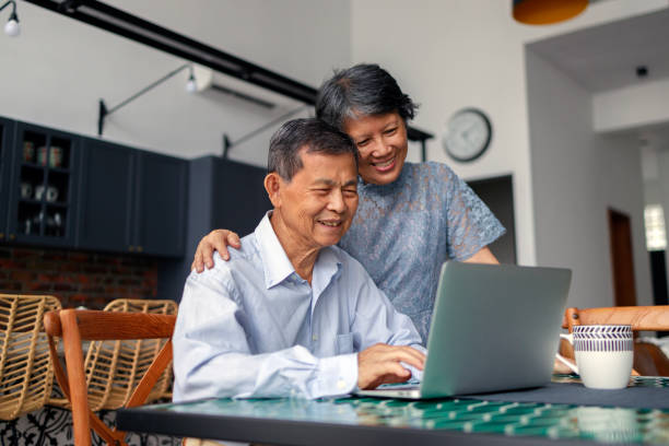 istock A cheerful and affectionate senior Asian couple are using a laptop together while relaxing at home. This heartwarming scene embodies the concept of elderly people embracing technology. 1484740046