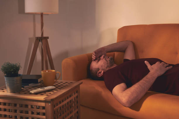 istock Man with stomach and head pain at home. 1484740933