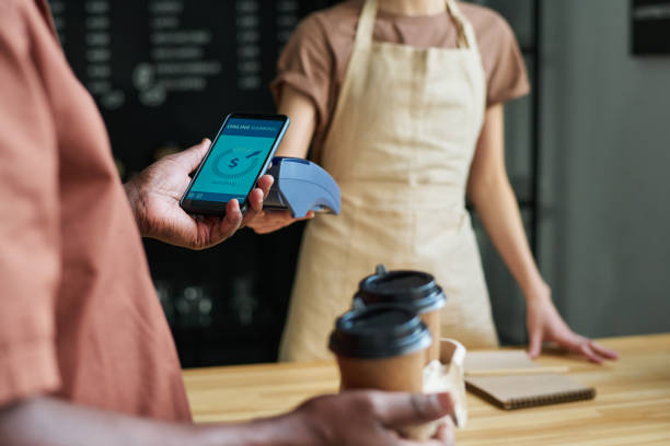istock Focus on smartphone held by mature man during contactless payment 1484742021