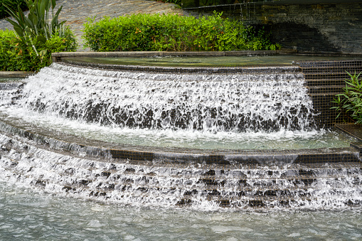 Landscape of man-made flowing water fountain in the park