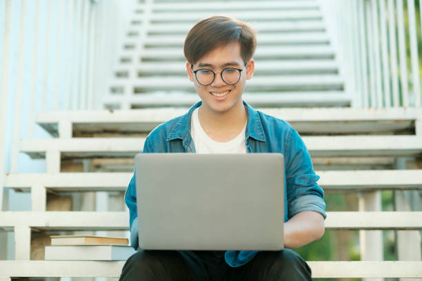 student studying outdoor using laptop. - using laptop contemplation accessibility contemporary imagens e fotografias de stock