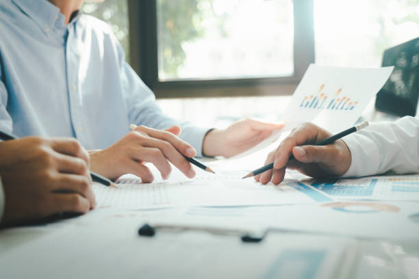 istock Businessmen working together at desk. 1484742455