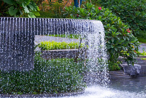 Landscape of man-made flowing water fountain in the park