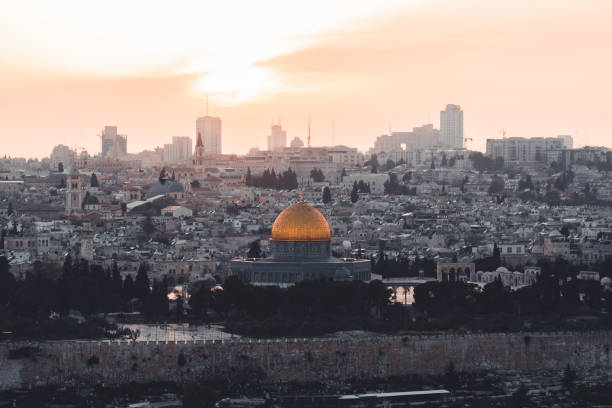 Jerusalem Old Town Cityscape of Temple Mount and Jewish Quarter at Sunset. Holy land view towards the iconic illuminated Al-Aqsa Mosque - Golden Dome of the Rock- and Bell Tower of the Church of the Redeemer,  Church of the Holy Sepulchre and Old Town City Wall. Jerusalem Old Town, Israel, Middle East.