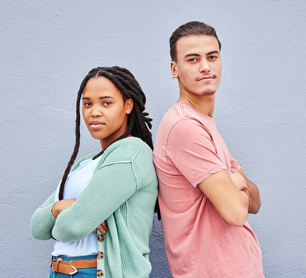 Diversity, friends and portrait of man and black woman standing together at wall background. Confidence, friendship and trendy creative gen z couple or students in studio with motivation and mock up.
