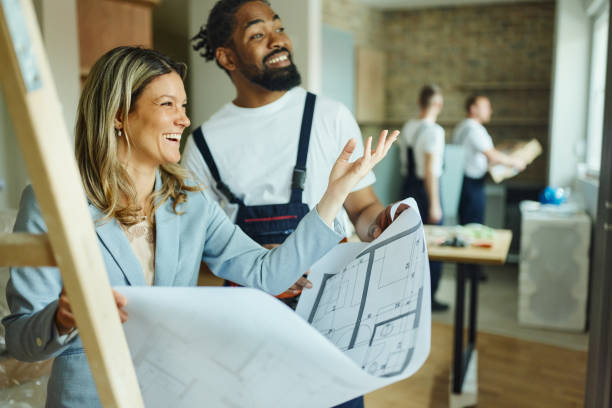 istock Happy female architect and black worker making plans in moving apartment. 1484753987