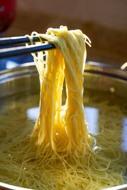 istock Cantonese style bamboo noodles being cooked in a pot 1484755041