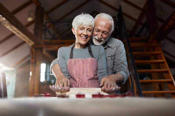 istock Happy senior couple kneading pastry dough in the kitchen. 1484756897