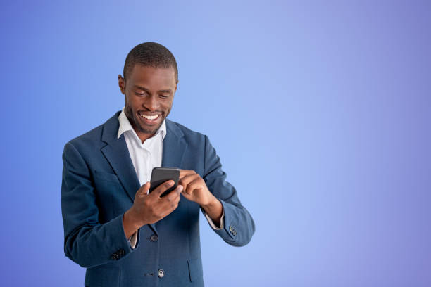 istock Black businessman with smartphone, copy space blue background 1484757120