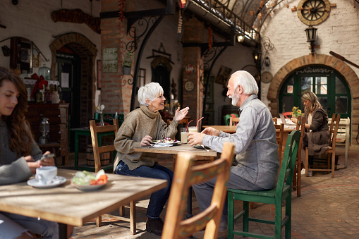 Happy mature couple enjoying in conversation during lunch in a restaurant.