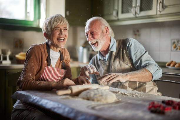 istock Cheerful mature couple having fun while making a cake in the kitchen. 1484757559