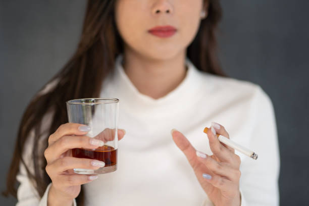 Asian woman hand drinking glass of alcohol and smoking cigarette Asian woman hand drinking glass of alcohol and smoking cigarette. dont smoke and drink asian  stock pictures, royalty-free photos & images