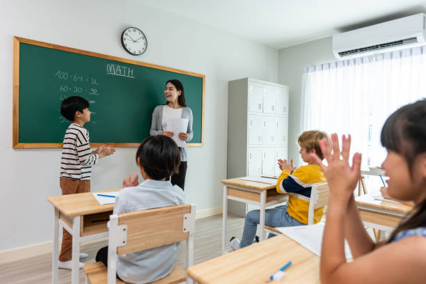 istock Group of student learn with teacher in classroom at elementary school. Attractive beautiful female instructor master explain and educate young children with happiness and fun activity at kindergarten. 1484760769