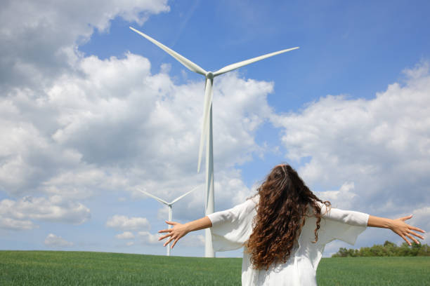 Happy cheerful caucasian woman is enjoying an outdoor activity in the daytime. Happy and healthy Asian woman is walking at the windmill park.