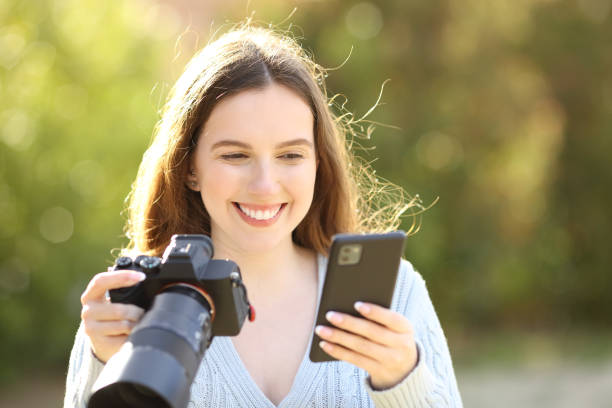 istock Happy photographer checking phone holding camera 1484762501