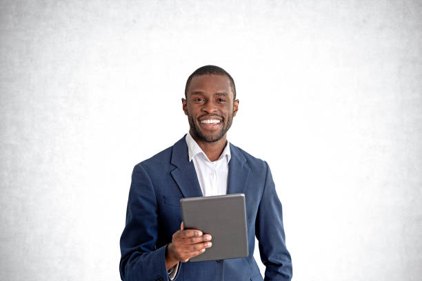 istock African man with tablet, concrete wall background 1484762578