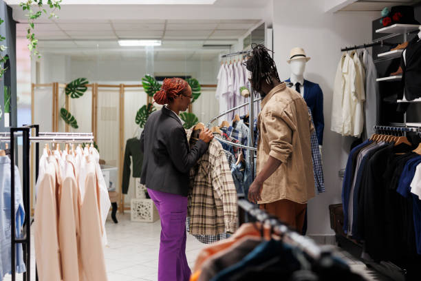 istock Clothing store assistant helping customer choosing shirt 1484763482