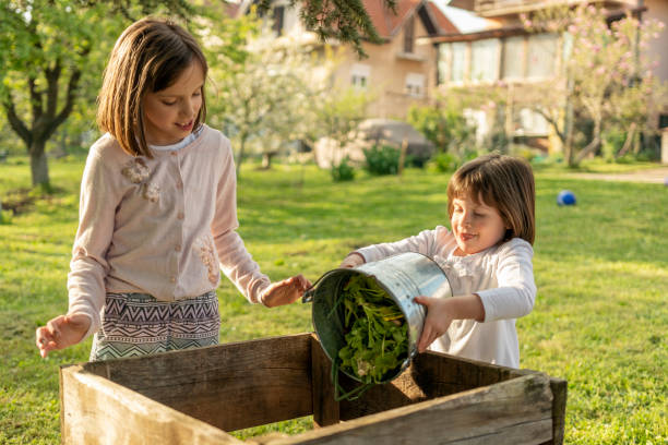 istock Children emptying kitchen waste in to a compost bin 1484765674