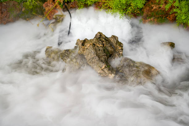 Cobblestones and rocks along the seacoast with smooth water through long exposure shot