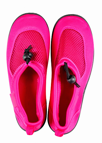 Pair of pink surf shoes with anti slip sole and tightening laces, clipping path, studio shot