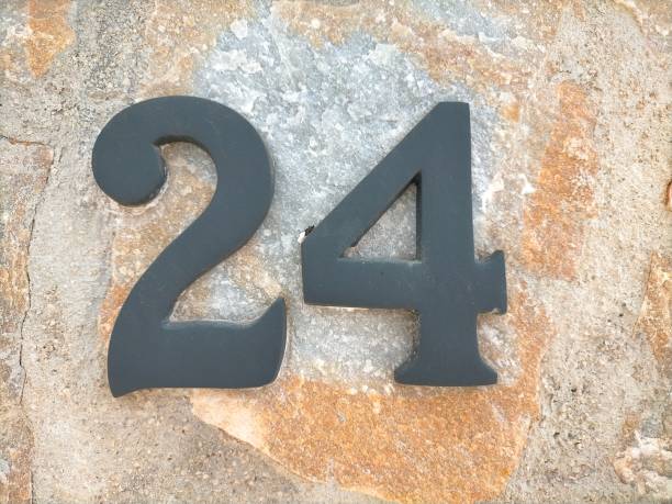 istock Twenty four,24 in black metal number on a light brown stone wall 1484773486