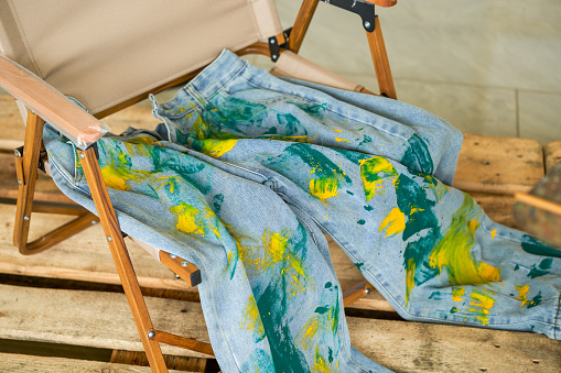 A pair of jeans stained with graffiti watercolor paint