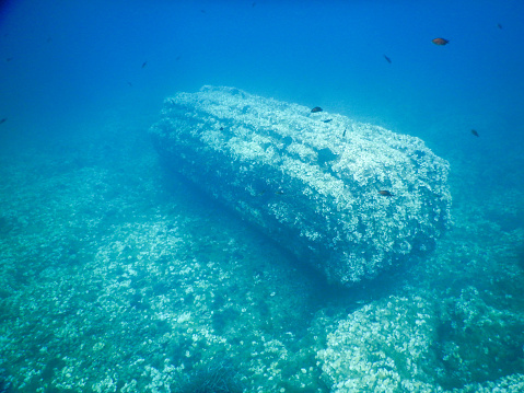 a sunken ship Underwater with a shoal of fish.