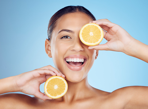 Lemon skincare, woman and beauty for portrait, clean wellness and studio background. Happy model, face and healthy citrus fruits for natural detox diet, facial nutrition and aesthetic dermatology