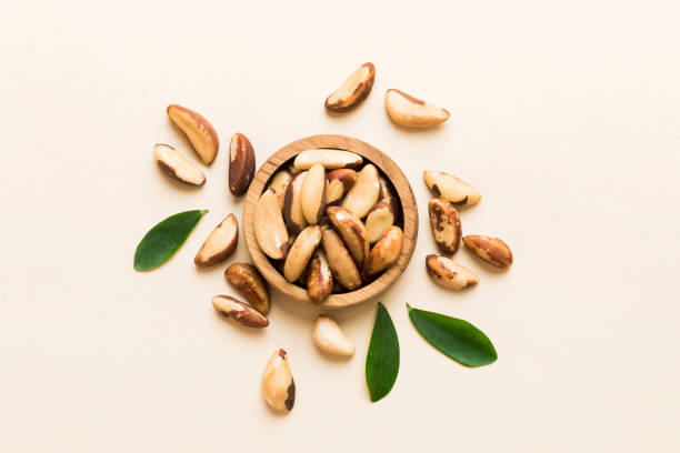 Fresh healthy Brazil nuts in bowl on colored table background. Top view Healthy eating bertholletia concept. Super foods Fresh healthy Brazil nuts in bowl on colored table background. Top view Healthy eating bertholletia concept. Super foods. chestnut food stock pictures, royalty-free photos & images