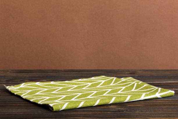 istock top view with green kitchen napkin isolated on table background. Folded cloth for mockup with copy space, Flat lay. Minimal style 1484777231