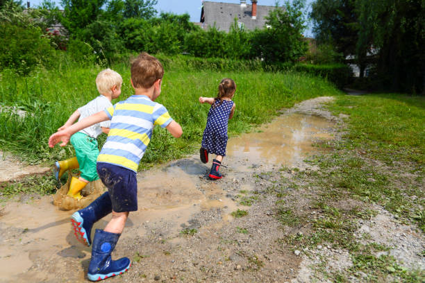 istock Children running on puddles of mudd 1484778997