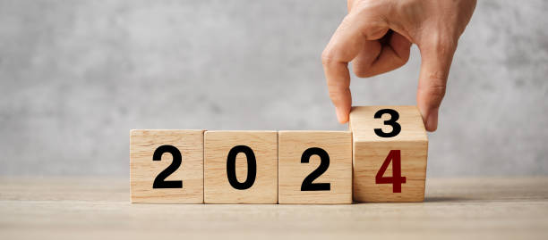 hand-flipping-block 2023 bis 2024 text auf dem tisch. vorsatz, strategie, plan, ziel, motivation, neustart, geschäfts- und neujahrsurlaubskonzepte - aiming challenge business throwing stock-fotos und bilder