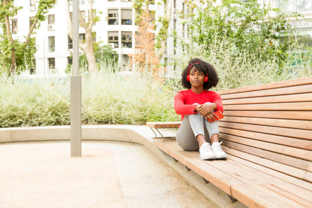 istock Smiling Afro woman on bench with copy space 1484783824