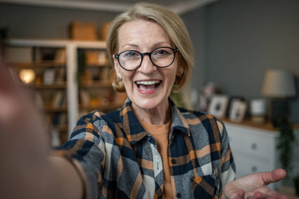 istock Caucasian mature woman taking selfie or video call using mobile phone or vlog camera having happy facial expressions 1484785298