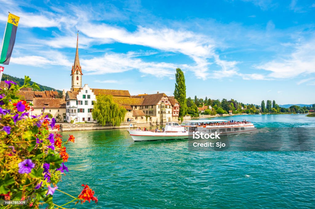 Ferry sailing on the river Rhine in Stein am Rhein Ferry sailing on the river Rhine in Stein am Rhein, Switzerland during a beautiful summer day. The ferry sails over the river Rhine and the Untersse between Schaffhausen and Constance on the shore of the Bodensee Cruise - Vacation Stock Photo