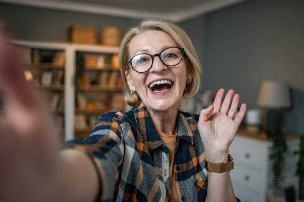 istock Caucasian mature woman taking selfie or video call using mobile phone or vlog camera having happy facial expressions 1484785898