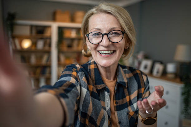 istock Caucasian mature woman taking selfie or video call using mobile phone or vlog camera having happy facial expressions 1484785909