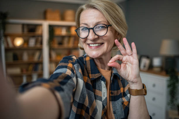 istock Caucasian mature woman taking selfie or video call using mobile phone or vlog camera having happy facial expressions 1484785912