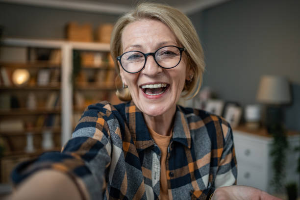 istock Caucasian mature woman taking selfie or video call using mobile phone or vlog camera having happy facial expressions 1484785941