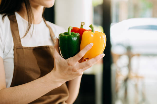 Fresh bell pepper holding by hand in sun light